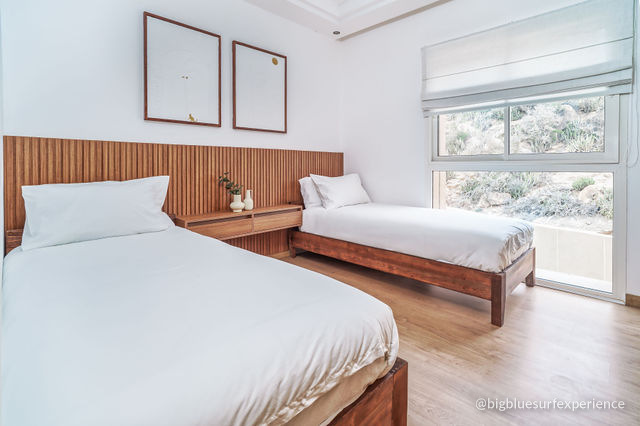 Twin bedroom of the BigBlue Bay Duplex with a window onto the hillside behind the residence