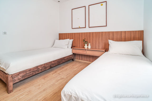 Twin bedroom of the BigBlue Bay Duplex with two single beds and a slatted wooden headboard