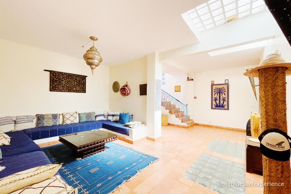 Blue majlis lounge with low seating and Moroccan rugs