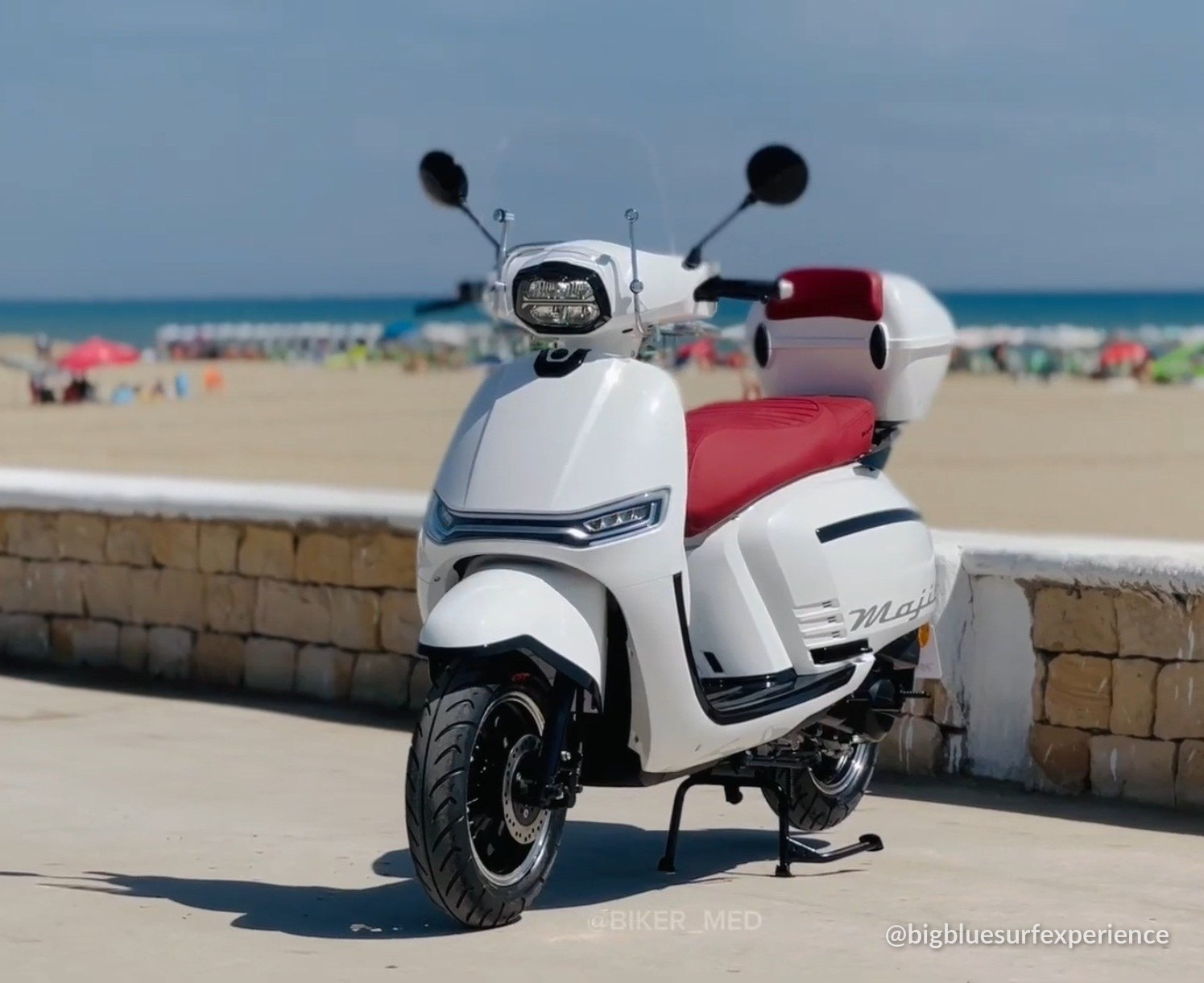 White 50cc scooter parked by the sea, the kind we rent