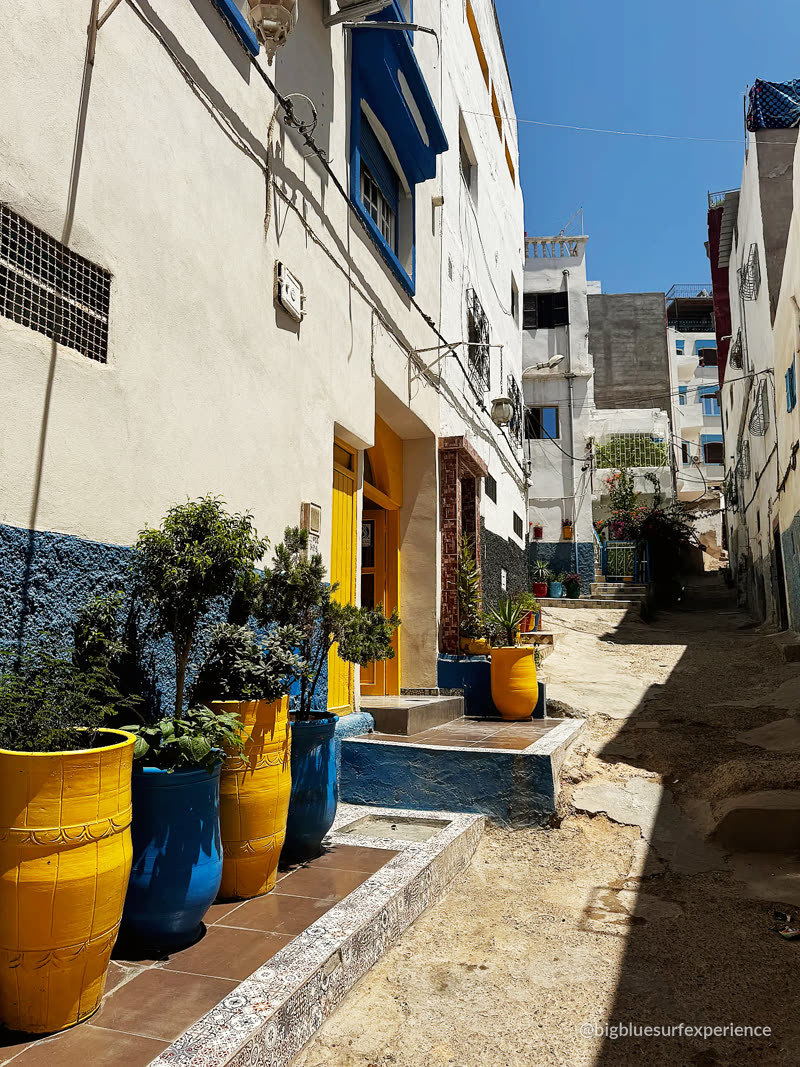 Alley in Taghazout village with blue and yellow pots